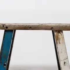 Banc rustique en bois, prêt pour une **rénovation meuble ancien**. Ses pieds bleus et blancs patinés racontent une histoire.