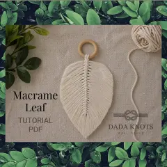 Décoration murale en macramé aux couleurs vives, avec des cordes torsadées formant des feuilles.