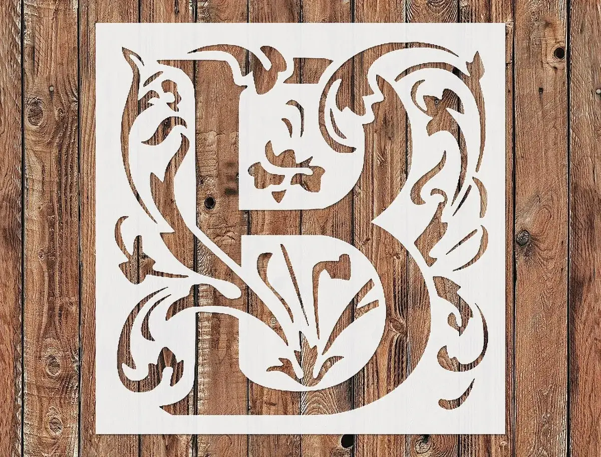 Pochoir lettre B orné de motifs floraux, sur fond de bois rustique. Idéal pour un projet de décoration personnalisé.